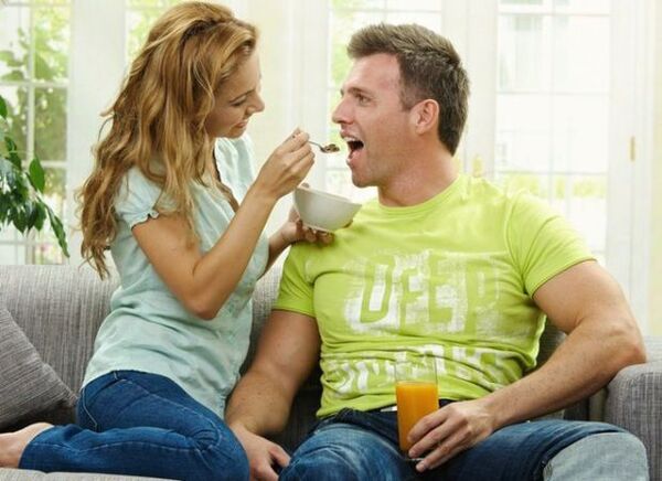 a woman feeds a man with potency-enhancing products